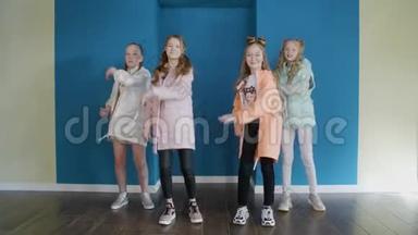 四个女孩的舞蹈四重奏，在蓝色演播室前镜头中跳舞。 舞蹈演员少女在舞蹈室跳舞。 舞者